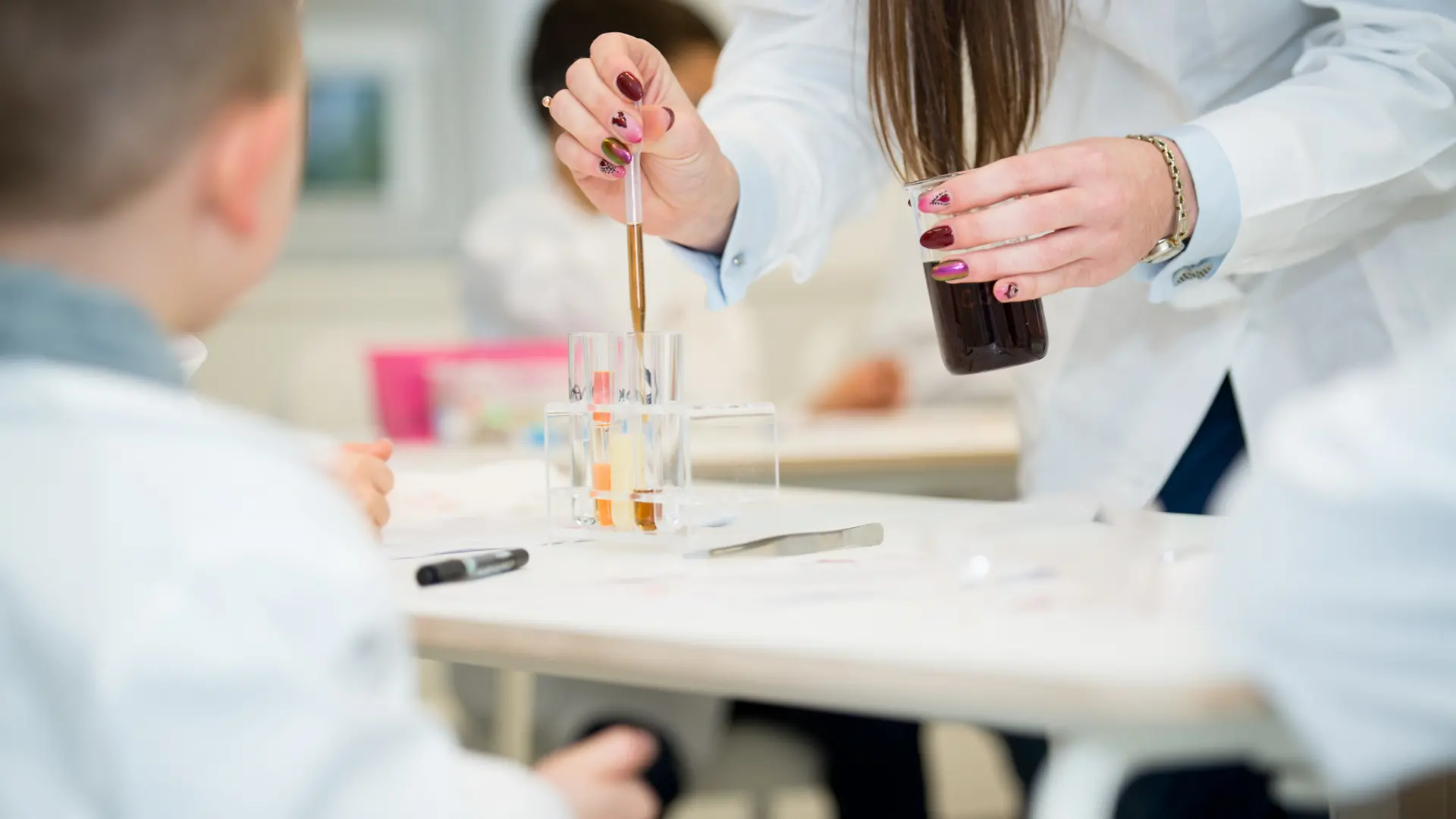 kobieta odmierzająca pipetą płyny w laboratorium