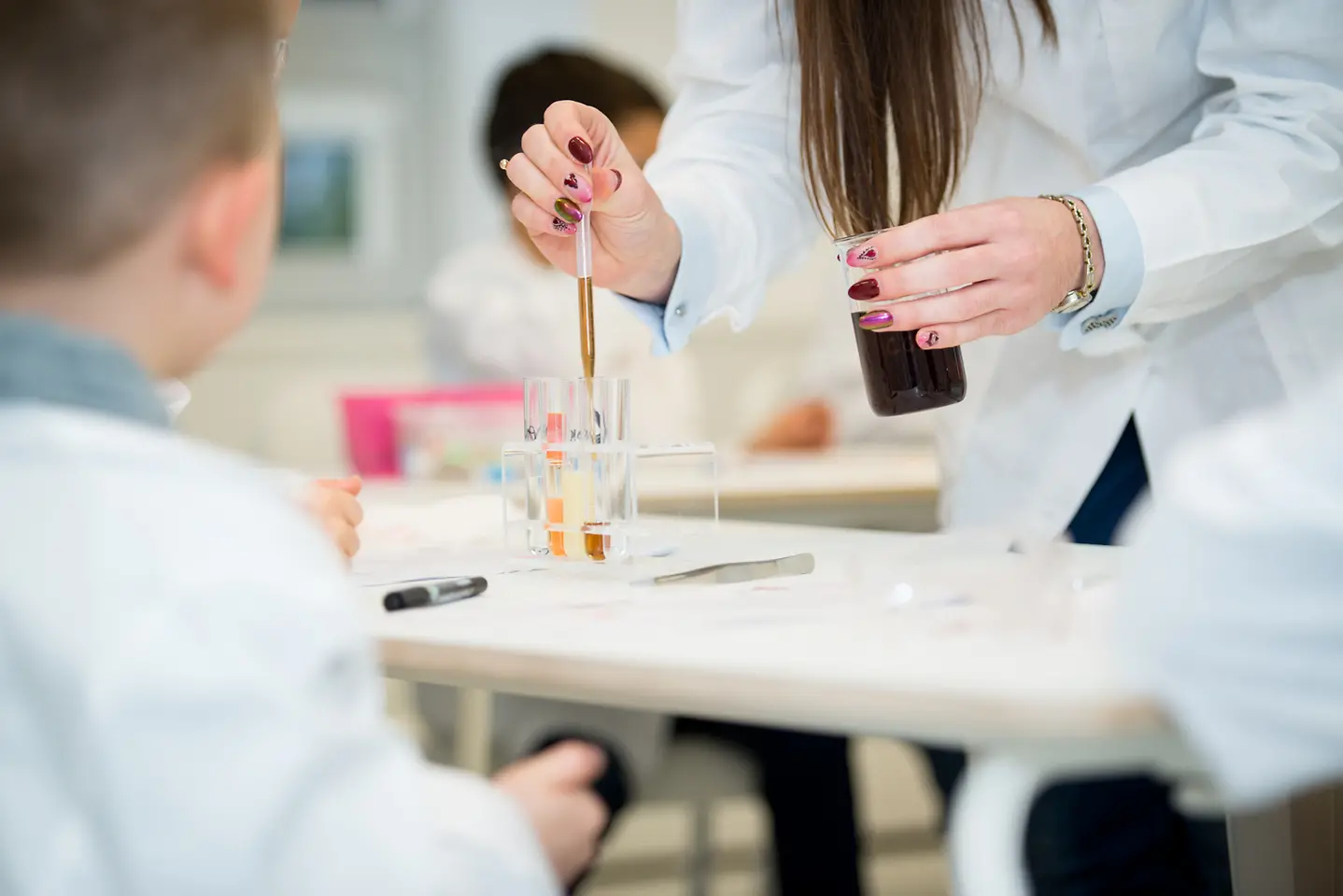kobieta odmierzająca pipetą płyny w laboratorium