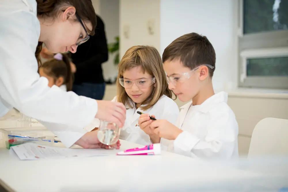 dzieci przeprowadzające doświadczenia w laboratorium