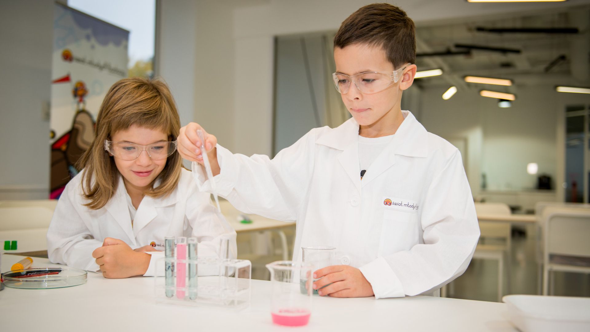dwoje dzieci przeprowadzających doświadczenia w laboratorium