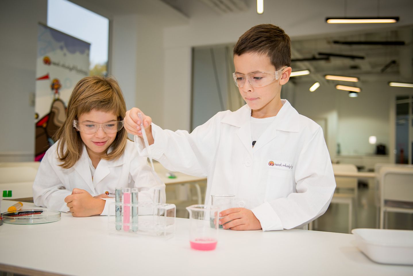 dwoje dzieci przeprowadzających doświadczenia w laboratorium